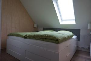a bedroom with a bed with a window on it at Vinnenhus Wohnung 06 in Cuxhaven