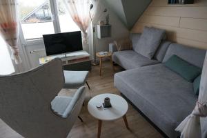 ein Wohnzimmer mit einem Sofa und einem TV in der Unterkunft Vinnenhus Wohnung 06 in Cuxhaven