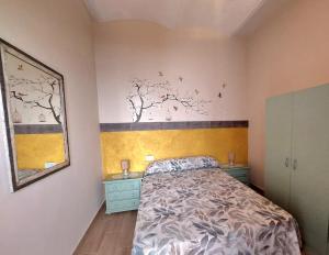 1 dormitorio con 1 cama, 2 mesitas de noche y un mural de árboles en La Plazuela, casa andaluza con patio., en Montoro