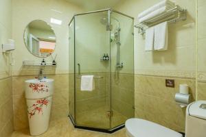 a bathroom with a glass shower with a toilet at Happy Dragon City Center Alley Hotel -In the city center with big window&heater, ticket service&Free Coffee&Food recommendation,Near Tian Anmen Forbiddencity,Easy to get traditional Walking area&Shichahai in Beijing