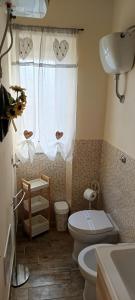 a bathroom with a toilet and a sink and a window at Casa Il Nido in Cagliari