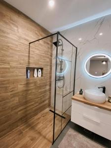 a bathroom with a glass shower and a sink at Owl's Nest Apartment in Cluj-Napoca +10 photos