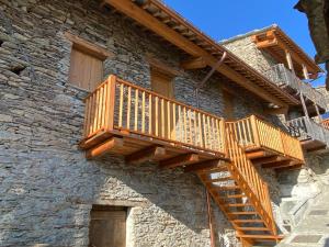 Ostana的住宿－BAITA GHITIN，石头建筑一侧的木楼梯