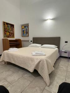 una camera da letto con un grande letto con asciugamani di Appartamenti Michela a Camogli