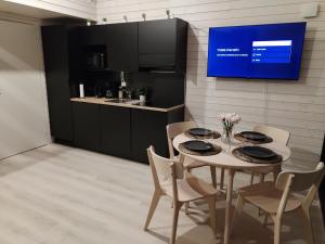 a dining room with a table and chairs and a tv at New cabin in Iso-syöte. Luokki 2 in Syöte
