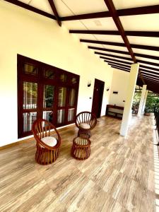 2 Stühle und ein Tisch in einem Zimmer in der Unterkunft Sigiriya Cashew Palace Resort in Daganapothaha