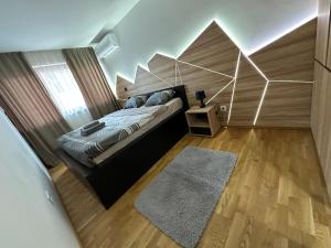 1 dormitorio con 1 cama con pared geométrica en MAR Residence 5 en Niš