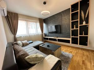 sala de estar con sofá y TV en MAR Residence 5 en Niš