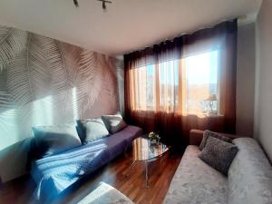 a living room with a couch and a window at Sunny Apartment in Rīga