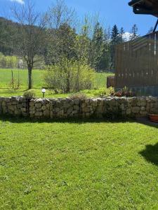 een stenen muur in een tuin naast een veld bij Pokój u Zosi in Zakopane