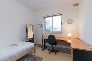 a bedroom with a desk and a bed and a chair at Sun Valley Suite - Hosted by Sweetstay in Mosta