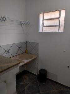 a white bathroom with a sink and a window at Plaza Hotel in Marabá