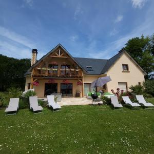 een groep witte stoelen op een gazon voor een huis bij Chez Kate et lolo in Senneville-sur-Fécamp