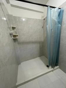 y baño con ducha con cortina azul. en La Casa de Ian en Santa Marta