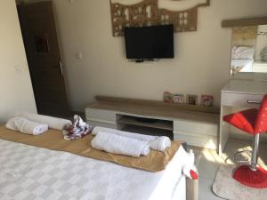 ein Wohnzimmer mit einem TV und einem Tisch mit Handtüchern in der Unterkunft Orka world in Fethiye