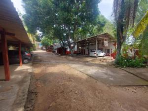 a dirt road next to a building with cars parked at Plaza Hotel in Marabá