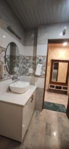 een badkamer met een wastafel en een spiegel bij Pomme Homestay in Kasauli