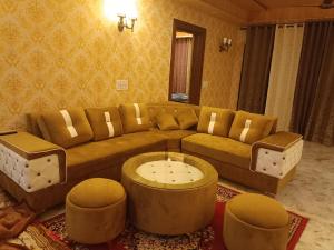 een woonkamer met een bank en een salontafel bij Pomme Homestay in Kasauli