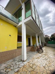 een geel gebouw met een fiets voor het gebouw bij Tota apartments in Shkodër