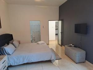 a bedroom with a large bed and a flat screen tv at Bianca's in Matola