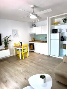 una cucina e un soggiorno con tavolo e sedie gialle di Hope house Lanzarote a Puerto del Carmen