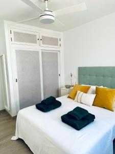 uma grande cama branca com duas almofadas verdes em Hope house Lanzarote em Puerto del Carmen