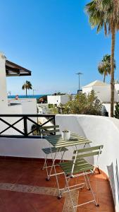 a patio with a table and chairs on a balcony at Hope house Lanzarote in Puerto del Carmen