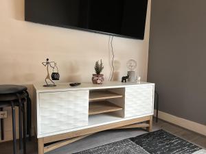 a white cabinet with a tv on a wall at Fab flat in Brentford