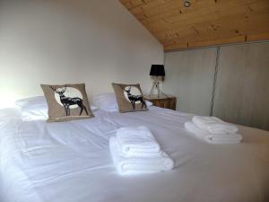 a white bed with towels and pillows on it at Chalet des Jonquilles - Au calme, bordant la forêt in Gerbépal