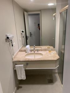 uma casa de banho com um lavatório e um espelho grande em Flat Jardim Paulista em São Paulo