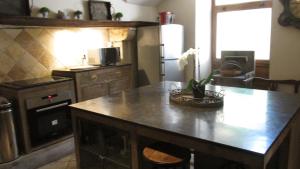 a kitchen with an island in the middle of it at Clos de Raveyron in Vallon-Pont-dʼArc