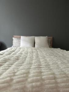 Una cama blanca con dos almohadas encima. en Fab flat en Brentford