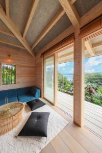 um quarto com uma mesa redonda e janelas grandes em Ryukyu Villa - Vacation STAY 11908v em Akaoki