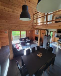 a living room with a table and a couch at Chalet des Jonquilles - Au calme, bordant la forêt in Gerbépal