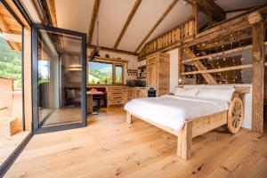 ein Schlafzimmer mit einem Bett in einem Zimmer mit Holzböden in der Unterkunft Unterkircher Chalet in Arriach