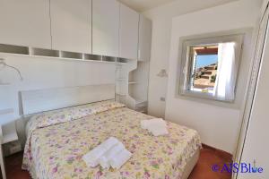 Un dormitorio con una cama con dos toallas encima. en C1. Comfort apartment, clima, shared swimming pool, en Costa Paradiso