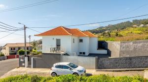 ein weißes Auto, das vor einem weißen Haus parkt in der Unterkunft Villa Angela- Madeira Inn Group in Calheta