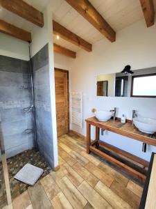 a bathroom with two sinks and a shower at Chalet des Jonquilles - Au calme, bordant la forêt in Gerbépal