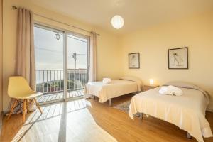 ein Schlafzimmer mit zwei Betten und einem großen Fenster in der Unterkunft Villa Angela- Madeira Inn Group in Calheta