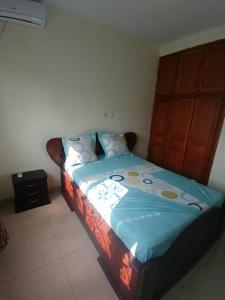 a bedroom with a bed with a blue comforter at Appartement luxueux de Bonaberi in Douala