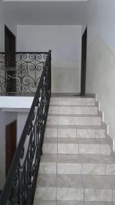 a staircase with a black railing and a stair case at Appartement luxueux de Bonaberi in Douala