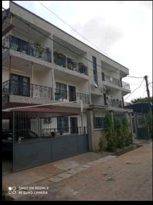 an apartment building with balconies and a garage at Appartement luxueux de Bonaberi in Douala