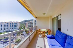 a balcony with a blue couch and a table at Amazing apartments in the modern Coruña building, near the beach, pool & garage in Villajoyosa