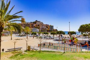 a beach with a playground and a city at Amazing apartments in the modern Coruña building, near the beach, pool & garage in Villajoyosa