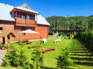 a house with a yard with benches and a playground at Chata Muszyna in Muszyna