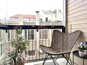a rattan chair sitting on a balcony with a window at Loft Itäpuisto By Borg Housing in Pori