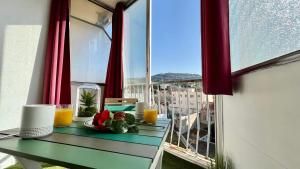 - une table avec deux verres de jus d'orange sur un balcon dans l'établissement Charmant Studio Cannes Centre - Idéal Vacance et congrés, à Cannes