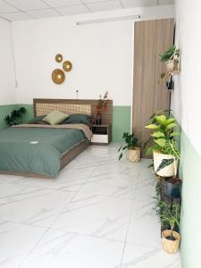 Un dormitorio con una cama y plantas. en The Hue Homestay en Thôn Dương Xuân Hạ