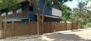 een blauw gebouw met een hek ervoor bij Pousada Caminho da Concha in Itacaré