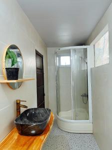 uma casa de banho com um chuveiro e uma banheira preta em The Hue Homestay em Thôn Dương Xuân Hạ